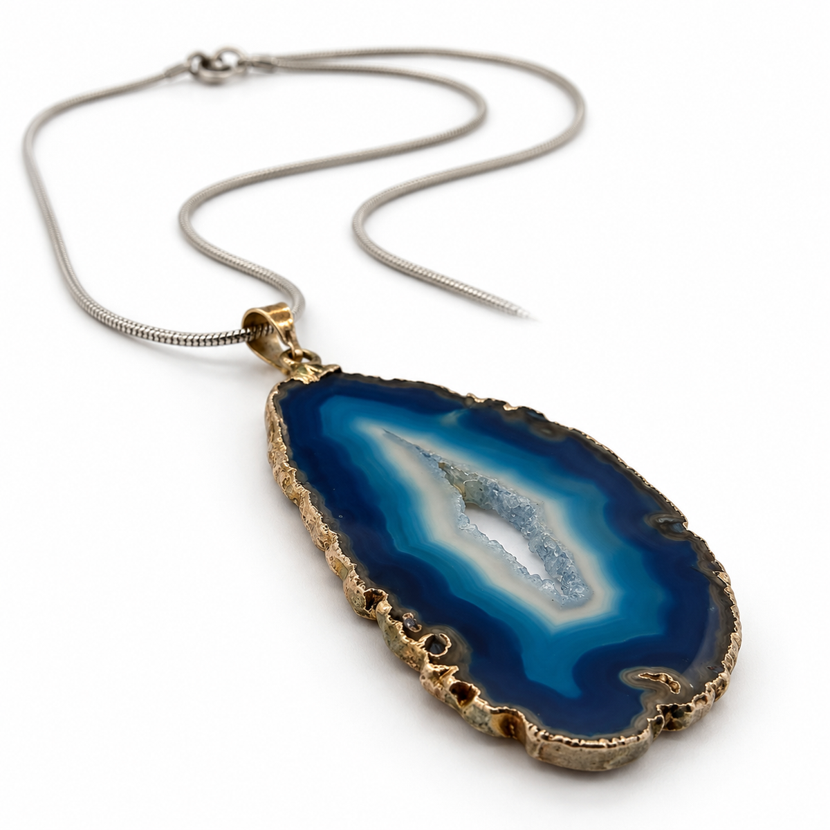 Blue agate slice pendant necklace viewed at low angle, showing gemstone depth and gold-tone edging