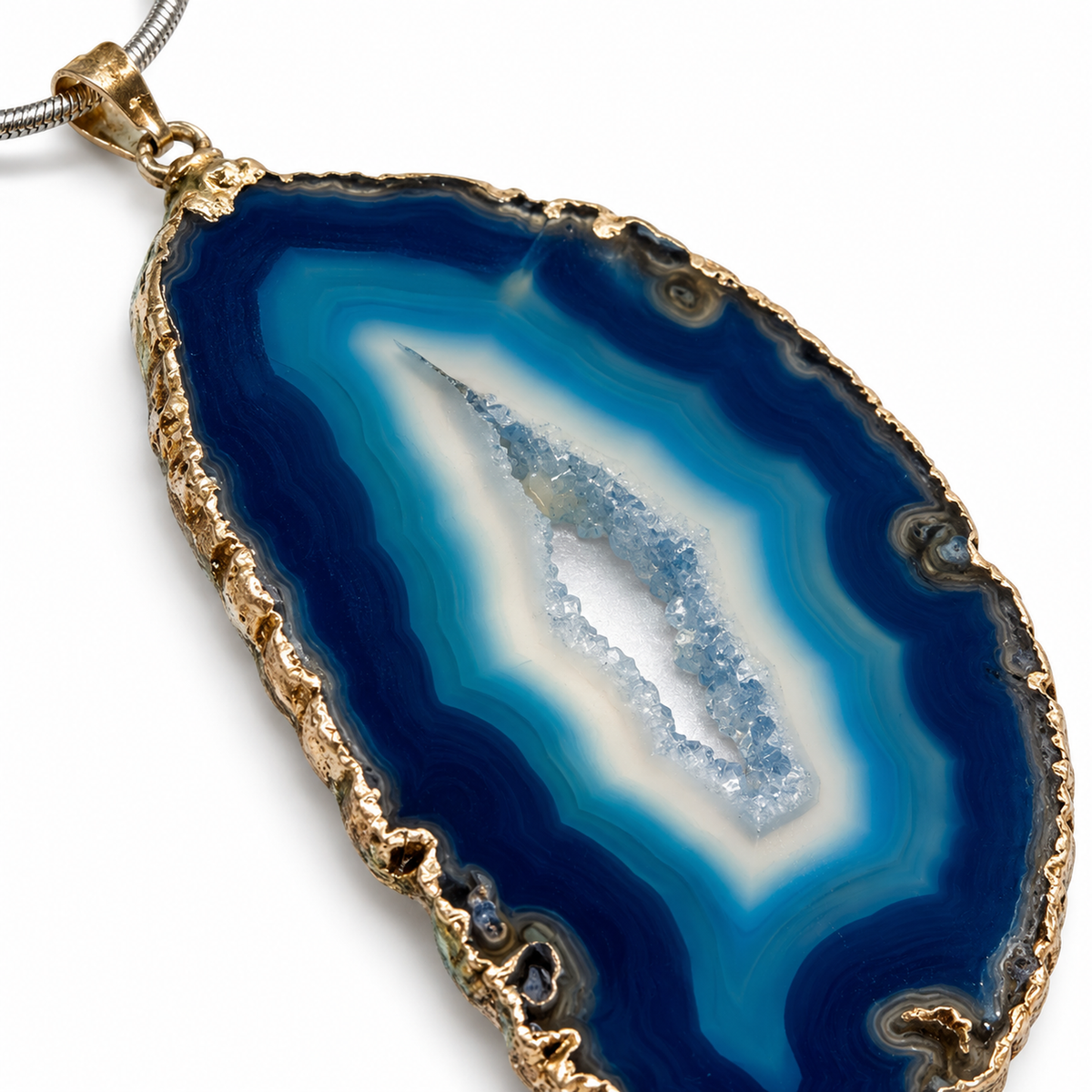 Macro detail of blue agate pendant showing real blue banding, crystalline center, and gold-tone edge
