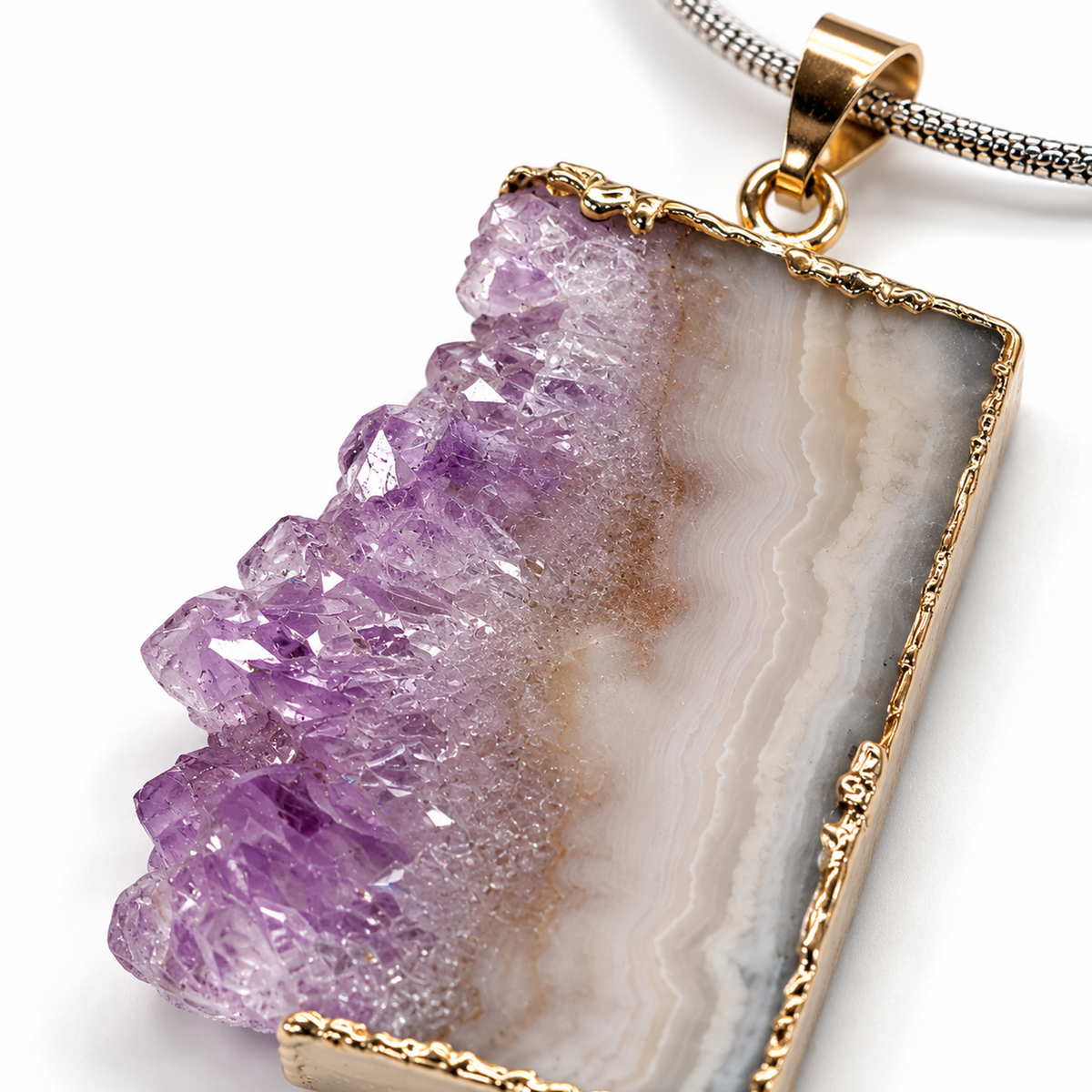 Close-up detail of amethyst druzy crystal formations, agate banding, metal edging and necklace bail