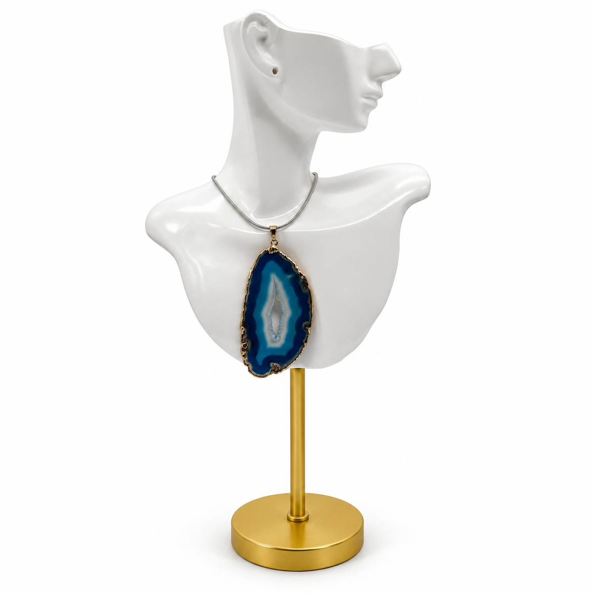 Blue agate slice pendant on glossy white ceramic jewelry bust with gold stand