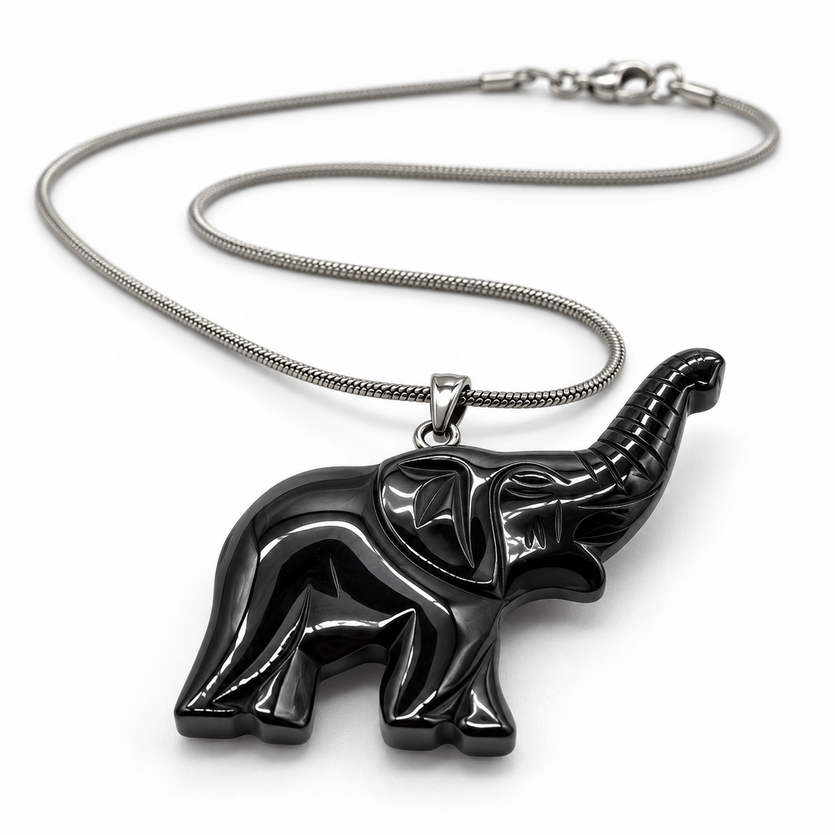 Low-angle view of the black carved elephant pendant showing its depth and silver-tone chain