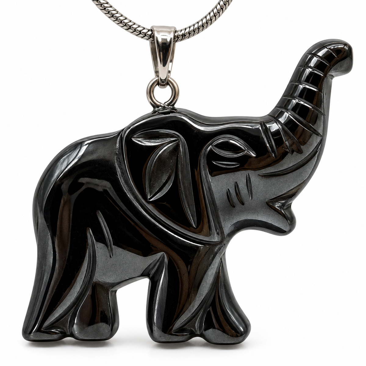 Macro close-up of black carved elephant raised trunk, engraved ear, face and silver-tone bail